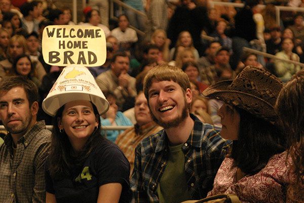 Brad Paisley fans waiting on the concert to begin. One fan is wearing a decorated lampshade on her head with a sign that reads "Welcome Home Brad" in honor of Paisley's hit single "Alcohol."