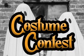 costume contest with two people dressed as ghosts in the background