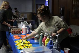 A craft assistant prepares paint for crafters at WVUp All Night