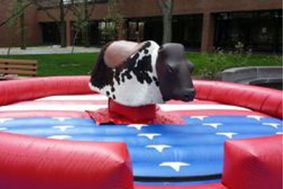 mechanical bull inside a red, white and blue inflatable arena