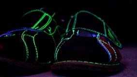 a pair of bowling shoes glowing green under the blacklight
