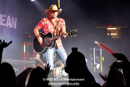Close up photo of Jason Aldean playing guitar on the Coliseum stage