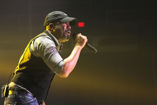 Darius Rucker bathed in yellow light singing on stage