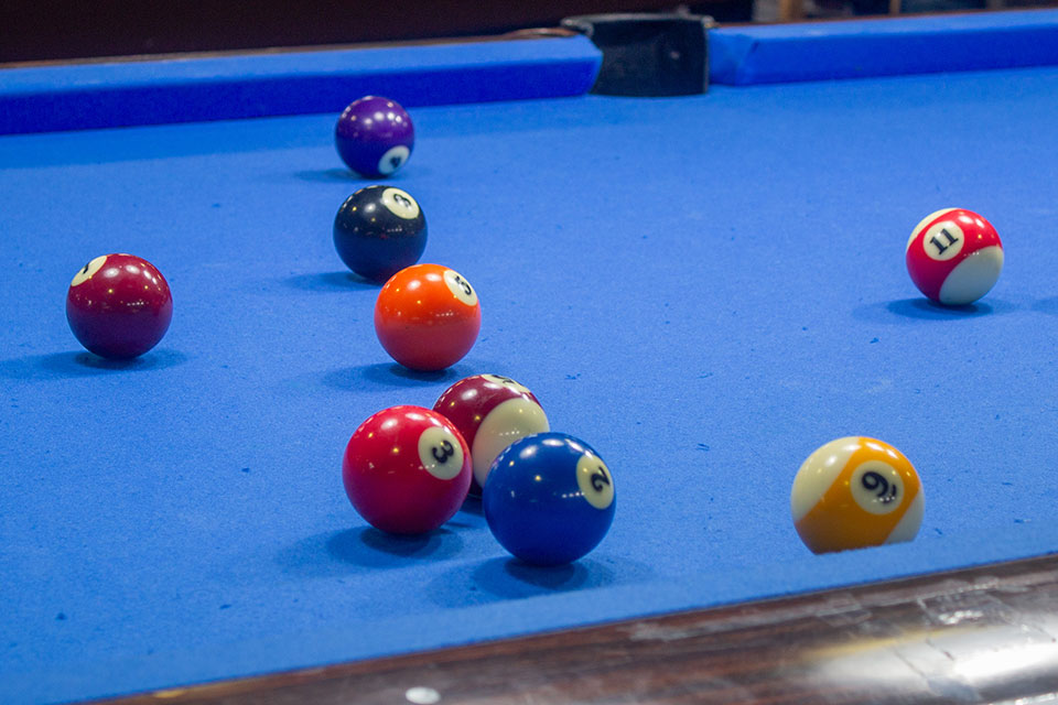 Various pool balls on a billiard table with blue felt.