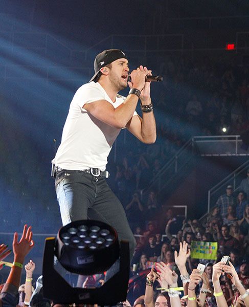 Luke Bryan with microphone on stage at the Coliseum in 2013