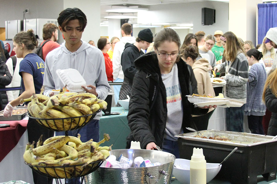 Students fill their plates in the breakfast buffet line