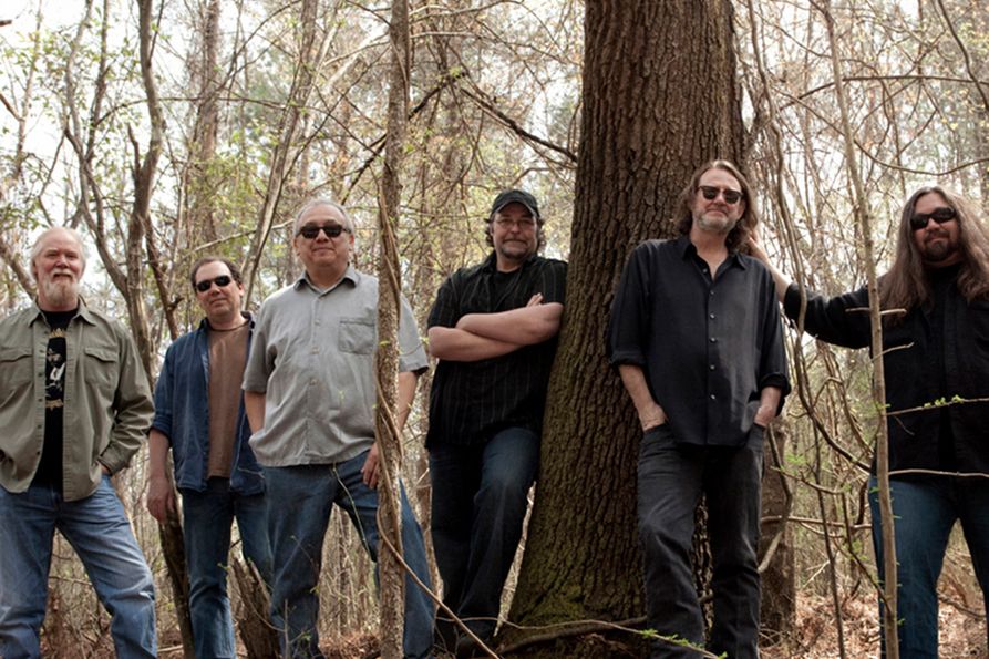 Members of Widespread Panic in a publicity photo set in the woods.