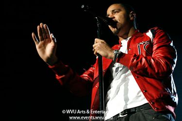 Cole performs on stage in his signature red leather jacket