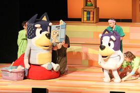 Puppeteers perform on stage with life-size characters in Bluey's Big Play The Stage Show.