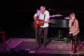 Neil Giraldo and Pat Benatar performing on stage at the WVU Creative Arts Center.