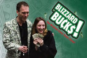 The host of Blizzard of Bucks in his suit decorated with money standing next to a female student with a handful of cash.