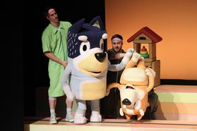 Puppeteers perform on stage with life-size characters in Bluey's Big Play The Stage Show.