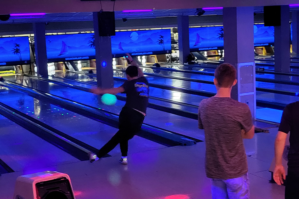 Student bowling under black lights in the Mountainlair Games Area