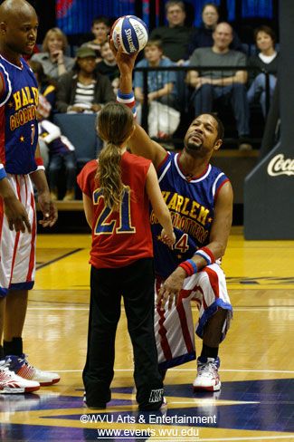 A Globetrotter interacts with a child from the crowd.