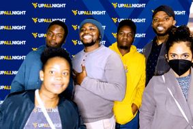 a group of students pose for a photo at the WVUp All Night photo booth