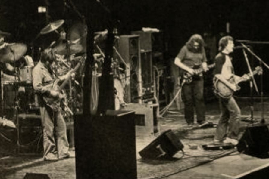 Black and white photo of the Grateful Dead performing at the Coliseum in 1983. Jerry Garcia and Bob Weir are both in the photo.