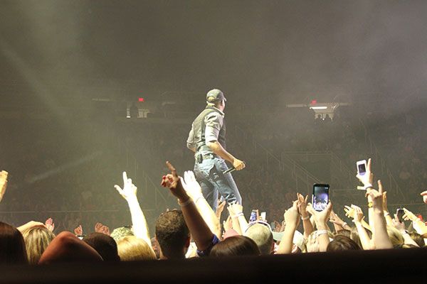 photo of the back of Darius Rucker taken from the pit showing fans recording the show on their phones