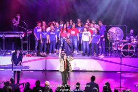 The Morgantown High School choir on stage with Foreigner at the WVU Creative Arts Center.