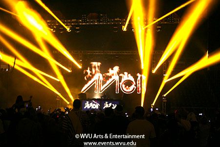 Wide shot of Coliseum stage with Avicii logo and gold lights