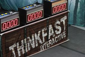 The set for the Think Fast game show showing three player stations with digital points boards