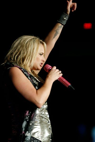 Miranda Lambert raises her left hand as she sings in 2011.
